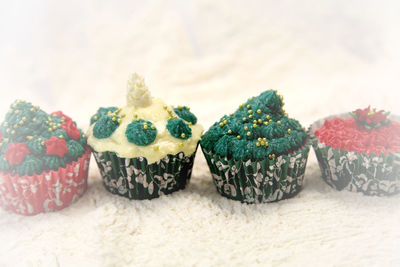 Close-up of multi colored christmas cupcakes on snow