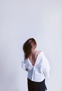 Rear view of woman standing against white background