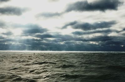 Scenic view of sea against storm clouds