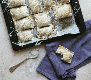 High angle view of pastry cakes in tray on stone table 