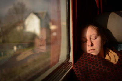 Woman looking at camera while sitting in train