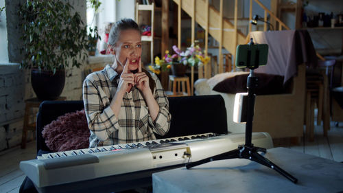 Woman learning piano from laptop