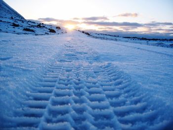 Close-up of snow against sky during sunset