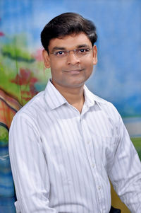 Portrait of man standing against wall