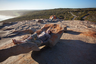 Full length of woman relaxing on rock at kangaroo island