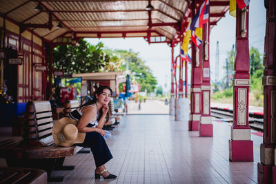 Woman sitting on seat in corridor