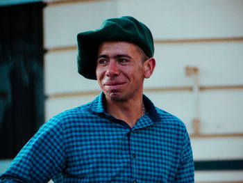 Portrait of smiling man standing against wall