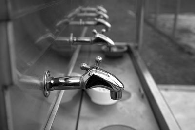 Close-up of faucets in public restroom