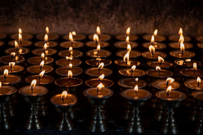 Close-up of lit candles in temple