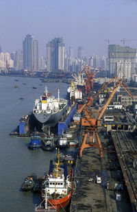 Boats in river with city in background