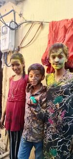 Portrait of girl standing against wall