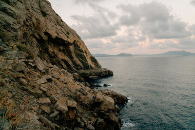 Rock formations by sea against sky