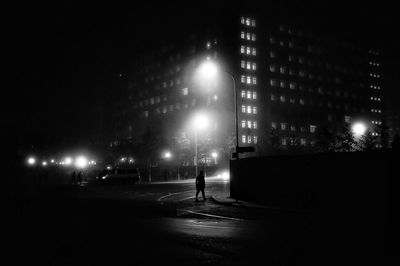 Man on illuminated street at night