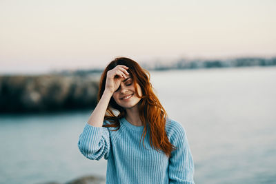 Young woman wearing hat standing against sky