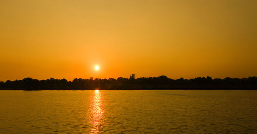 Scenic view of lake against clear sky during sunset