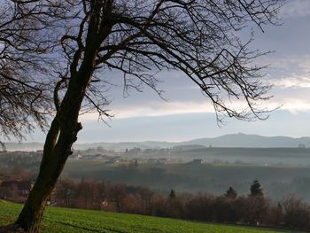 Scenic view of field against cloudy sky