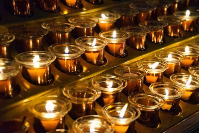 Illuminated candles in rack