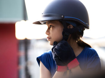 Close-up of girl wearing helmet looking away