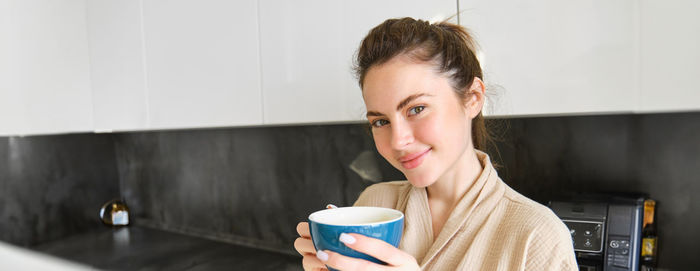 Young woman drinking coffee at home