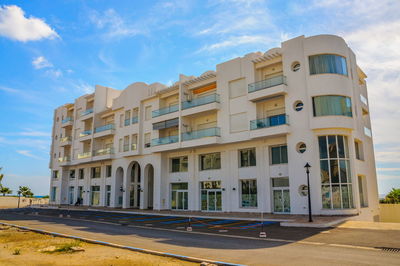 Building by road against sky in city