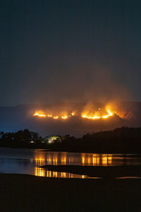 Scenic view of lake against sky at night