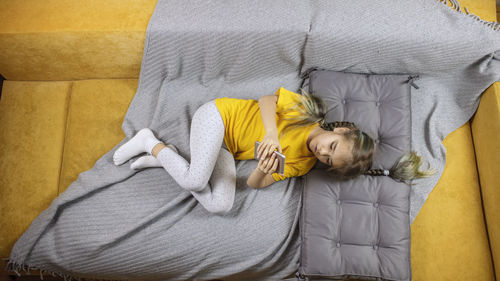 High angle view of man relaxing on bed