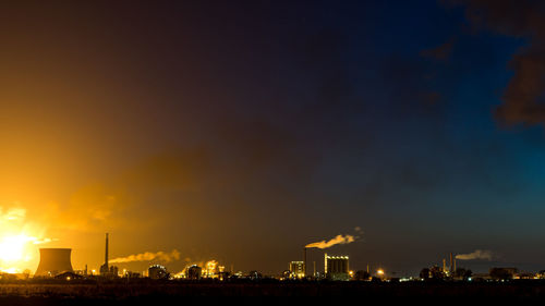 Illuminated city against sky at night