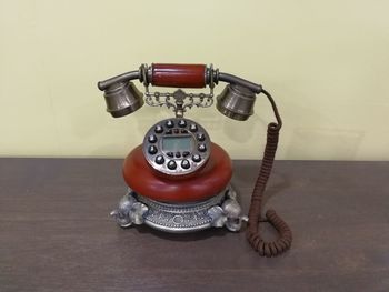 Close-up of telephone booth on table against wall