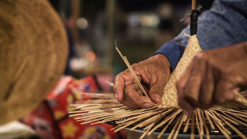 Close-up of hands weaving hat