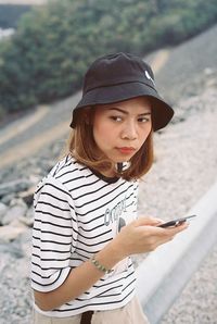Young woman using mobile phone while standing outdoors