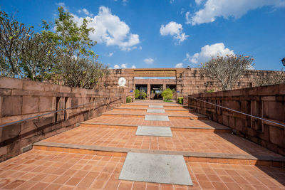 Footpath leading towards building against sky