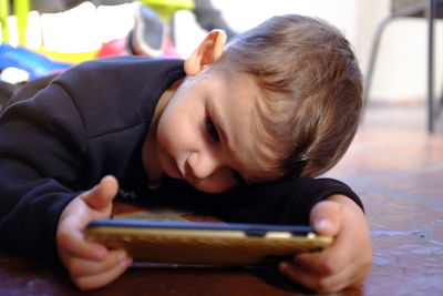 Rear view of boy using mobile phone