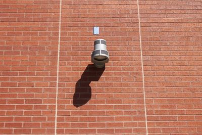 Man with umbrella on brick wall
