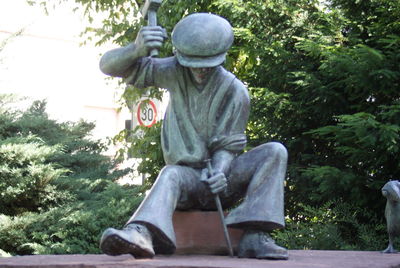 Low angle view of man sitting against trees