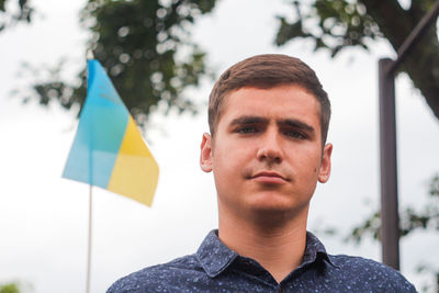 Ukrainian man. young serious man holding ukrainian flag. no war. support for ukraine. patriotic 