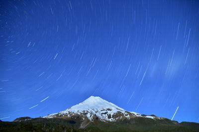 Low angle view of snowcapped mountain against sky at night
