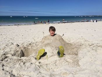 Boy on beach against sky