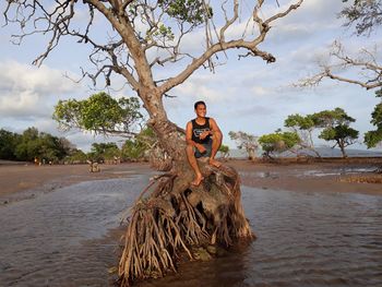 Portrait of man standing on beach against sky