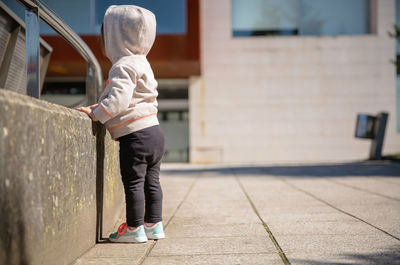 Rear view of boy standing against wall