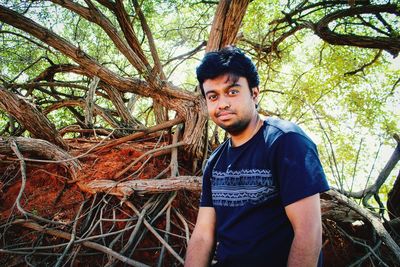 Portrait of young man standing in forest