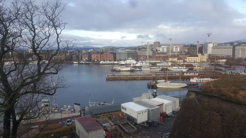 High angle view of buildings by river against sky