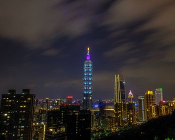 Illuminated buildings against sky at night