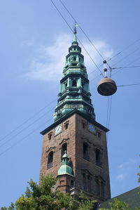 Low angle view of clock tower amidst buildings against sky