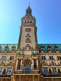 Low angle view of clock tower against blue sky