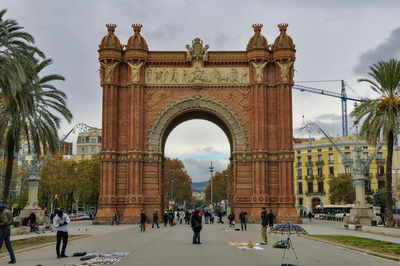 People at historical building against sky