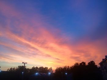 Silhouette trees and buildings against sky during sunset