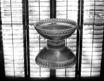 Reflection of bowl on table against window