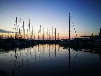 Silhouette of boats moored at harbor