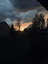 Silhouette trees and buildings against sky during sunset