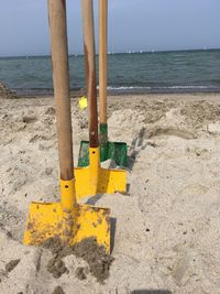 Yellow umbrella on beach against sky